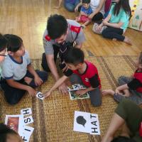 Sin Yung teaching the children to spell