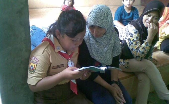 Bekasi's Team of Indonesian Reading Volunteering Scouts read for parents in their school.